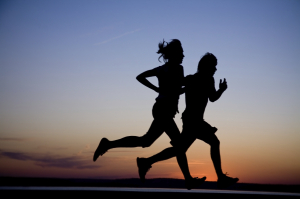 Young couple run together on a sunset